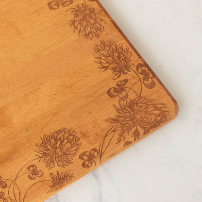 24 x 14 x 0.6 in maple artisan charcuterie board with heirloom distressed finish and hand-engraved clovers on a white background.