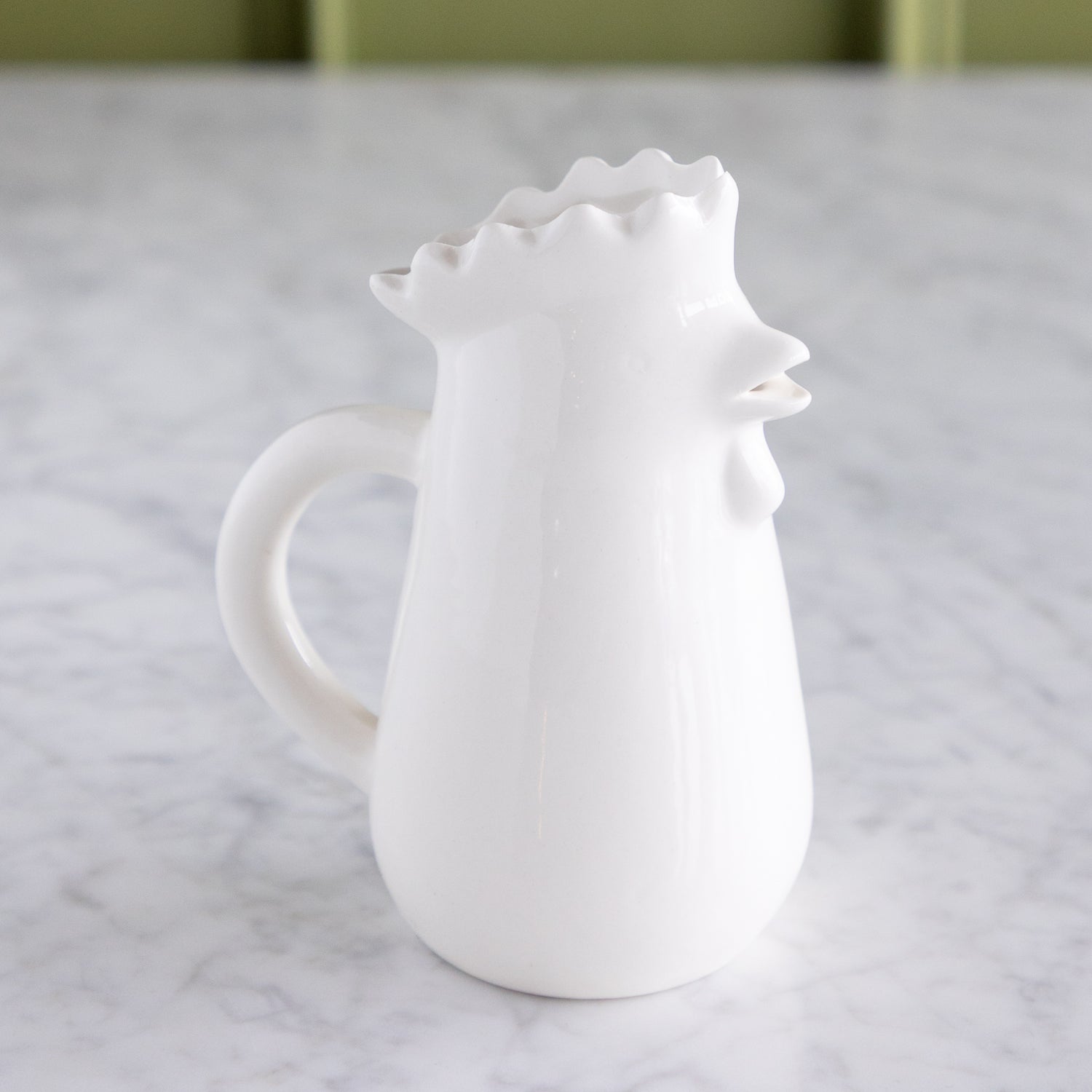 Stoneware Chicken Creamer on a marble table.