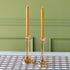 Amber Glass Taper Holders with orange taper candles on the Brown Painted Check Runner against a green wall.