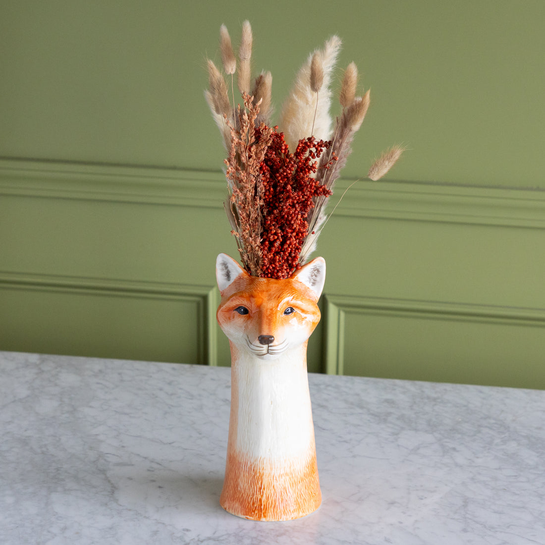 Fox shaped vase with dried flowers in it. 
