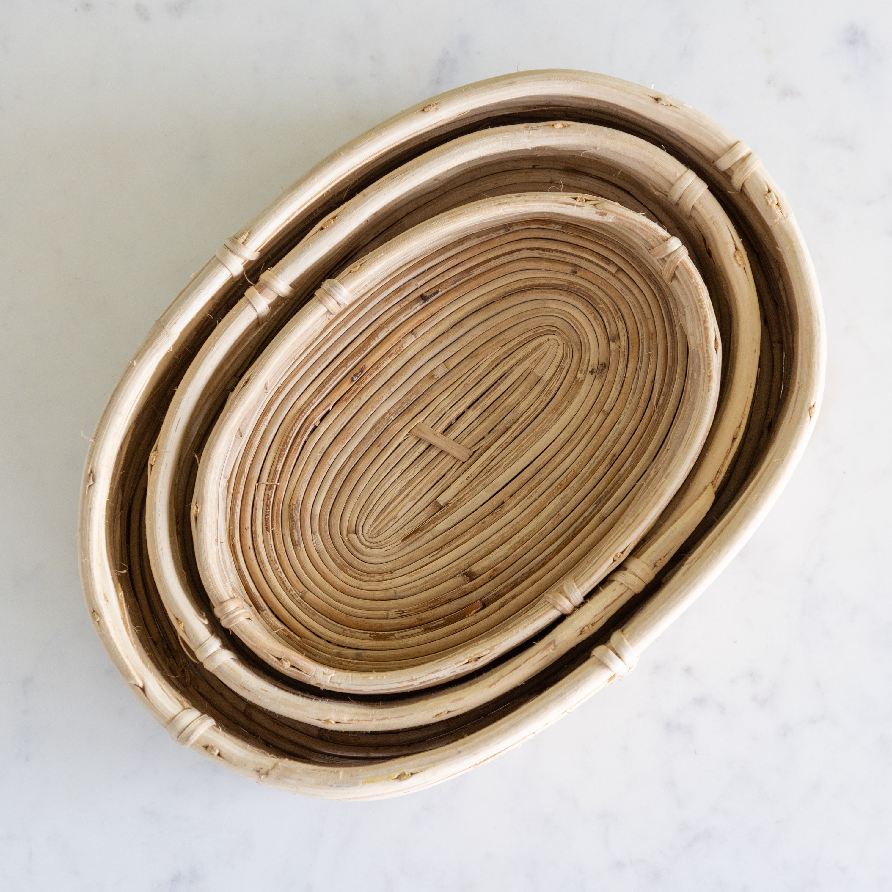 Stack of woven baskets on a marble surface