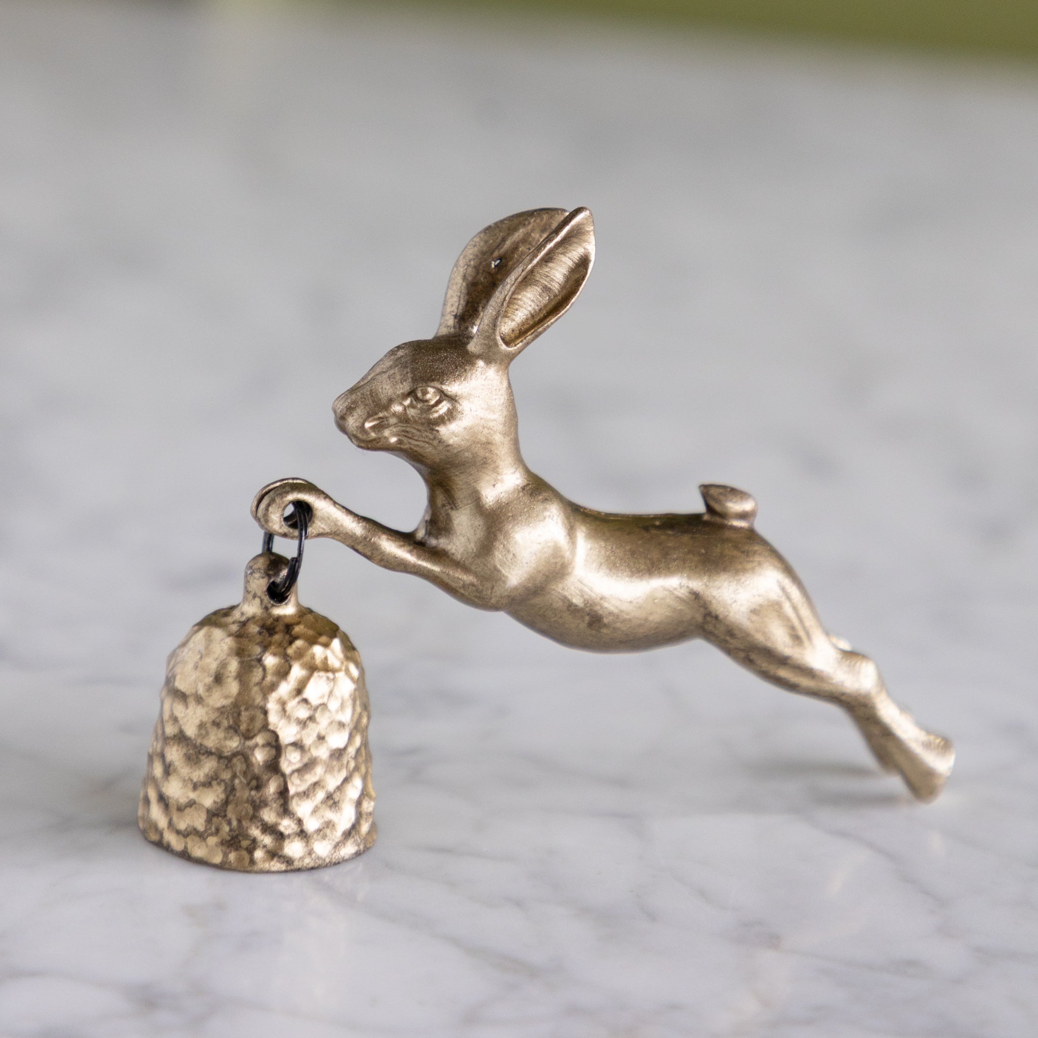 Pewter Gold Rabbit Shaped Candle Snuffer on a marble table.