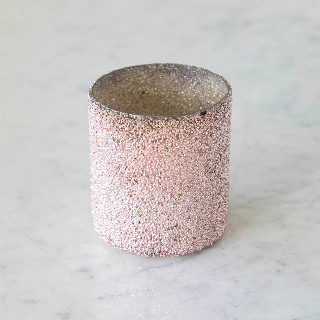 Pink Shimmer Votive on a marble table.