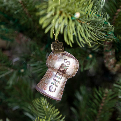 Cheers Cork Ornament hanging on a tree.