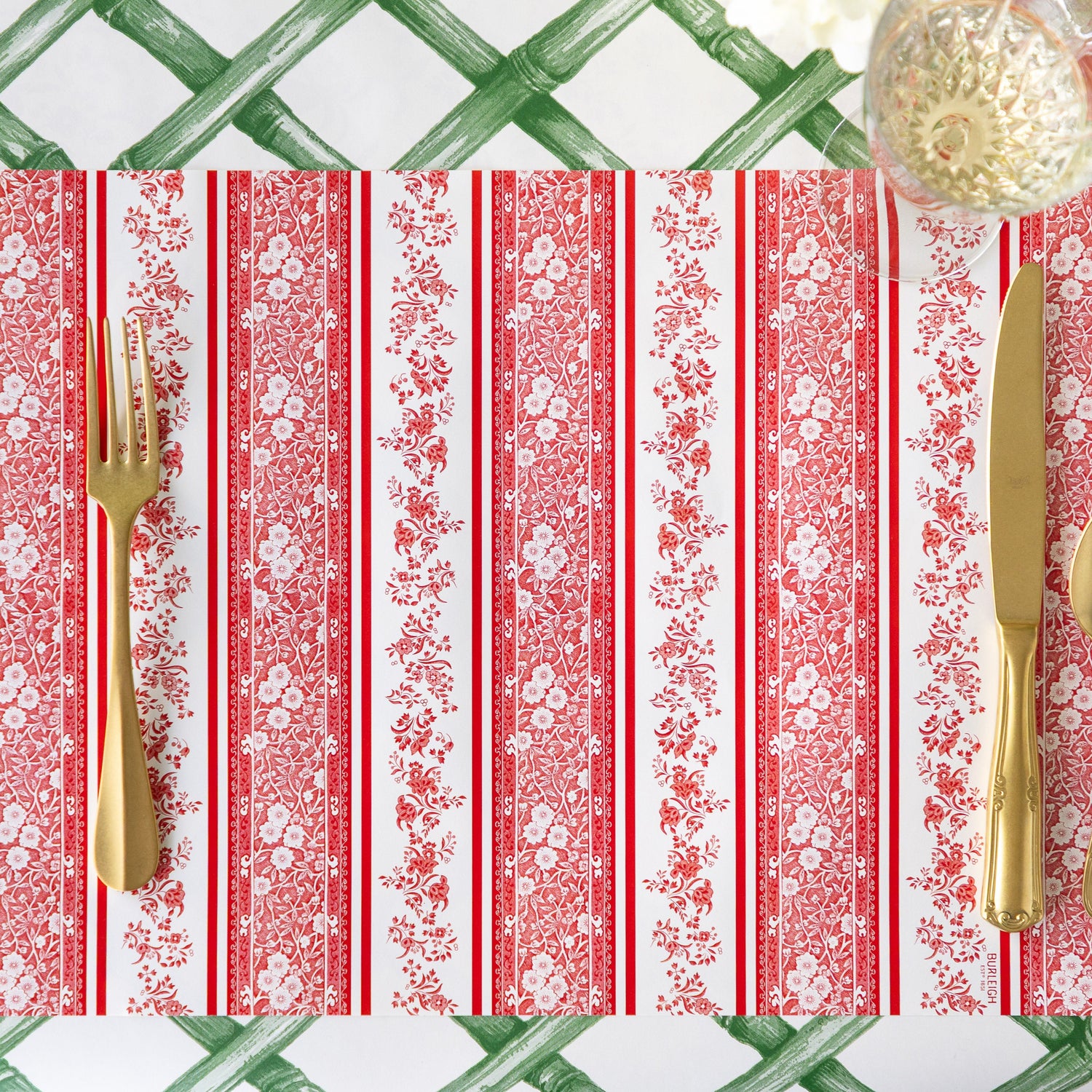 The Red Burleigh Stripe Placemat with gold flatware and glass of wine atop, and Green Lattice Runner underneath.
