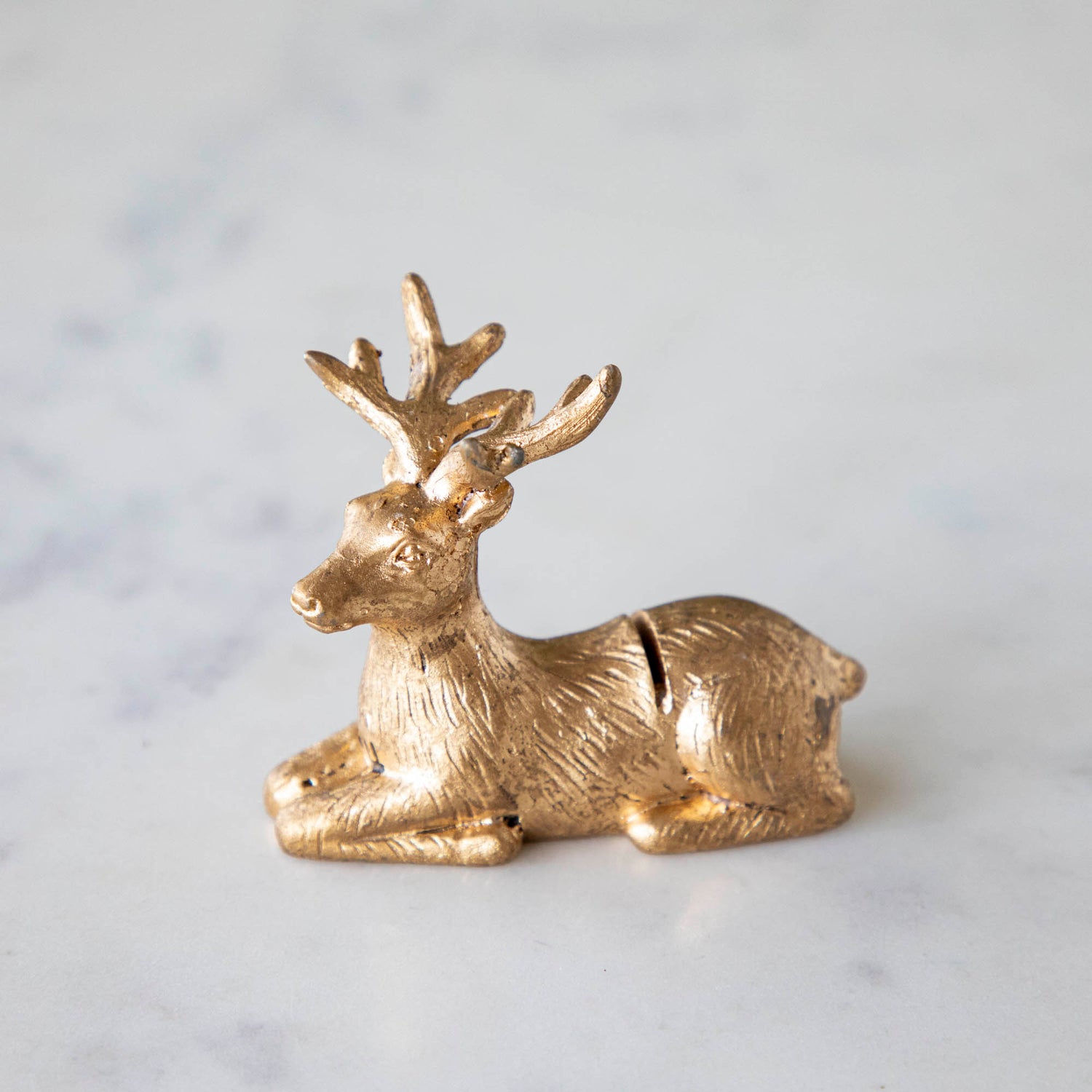 A side view of the Deer Place Card Holder on a marble table.