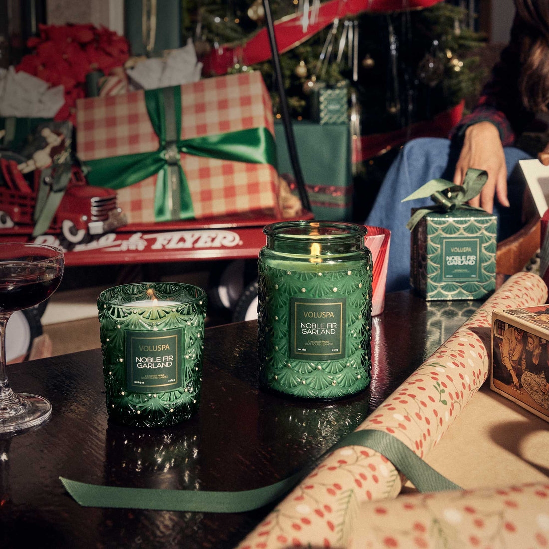 Christmas setting with two Noble Fir Garland candles burning in foreground 