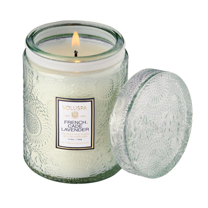 Two Voluspa French Cade Lavender candles on a marble surface with lemon verbena matchsticks.