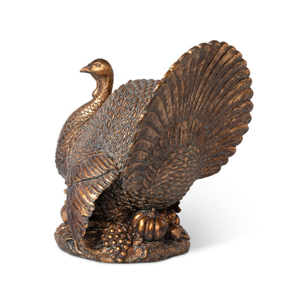 A side view of the Antique Bronze Turkey showing its detailed, fanned out tail fathers and pumpkins at its feet.