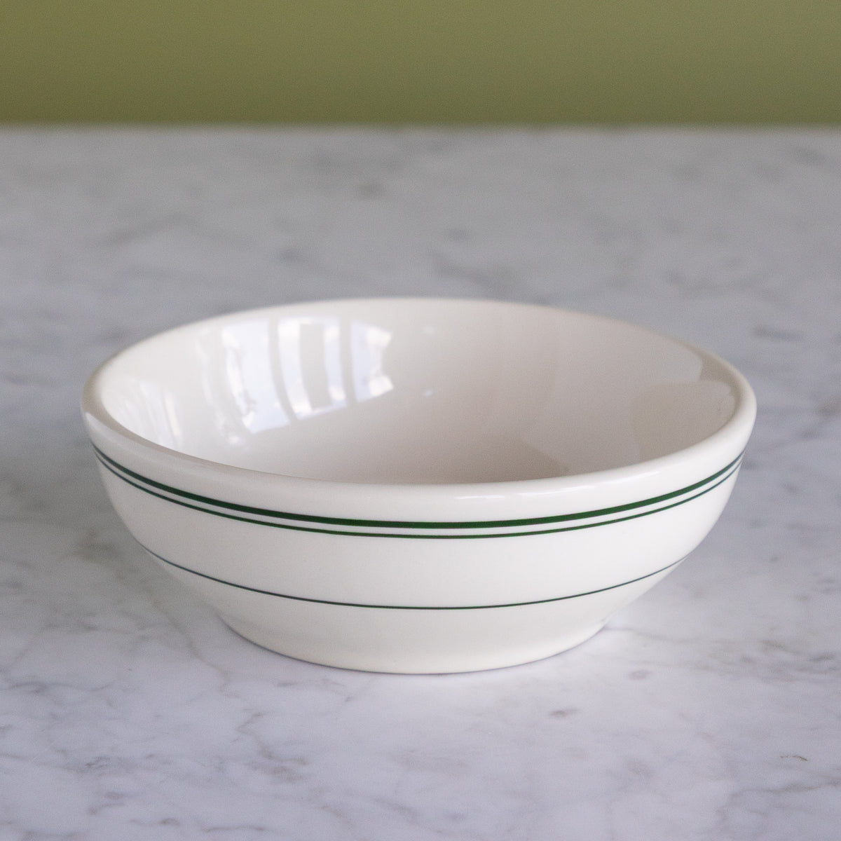 A white porcelain 14-ounce bowl featuring classic green stripes around the upper rim.