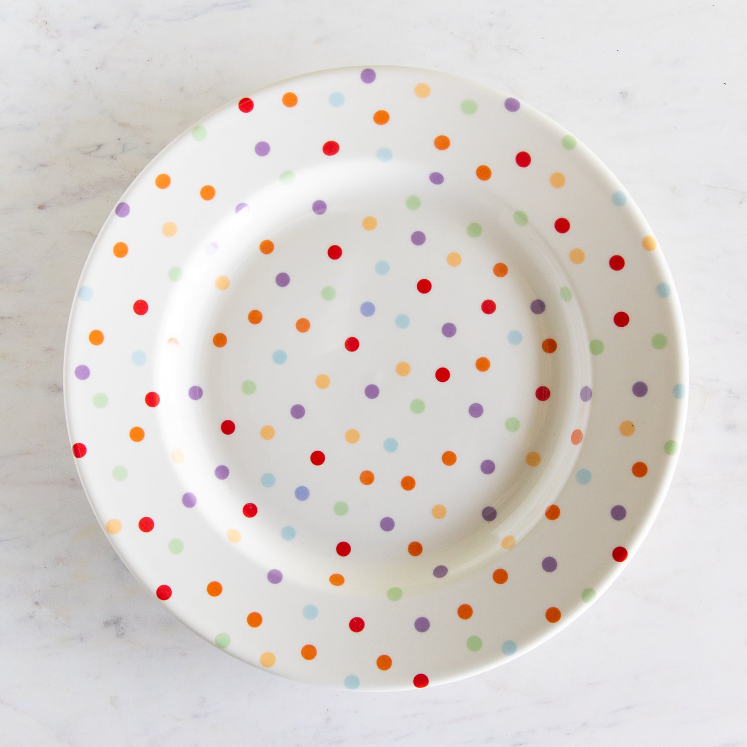 Polka dot plate with multicolor dots on a white background.