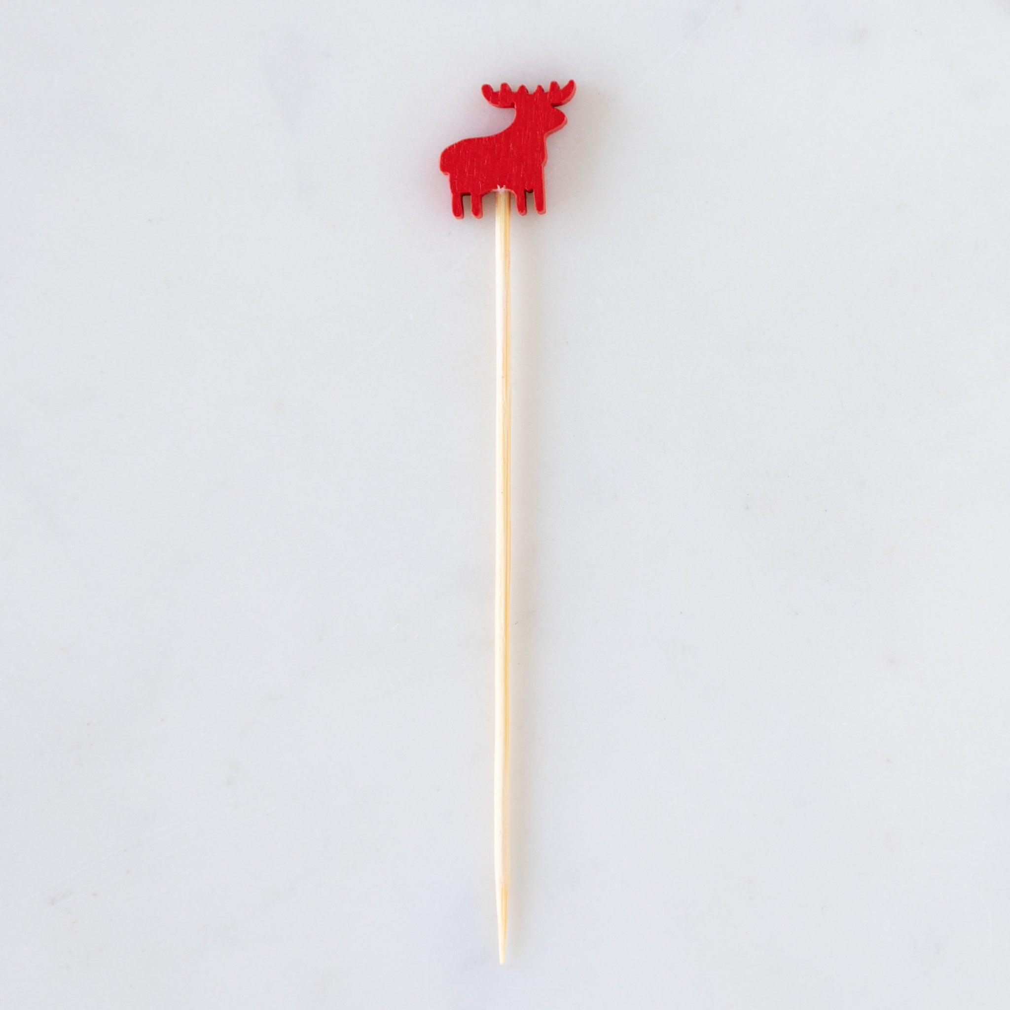 Wooden skewer with a red deer-shaped top on a white background.