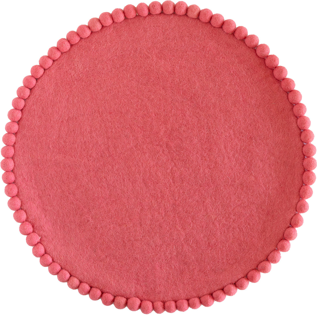 Pink colored round felt placemat with small pom poms around the edge. 