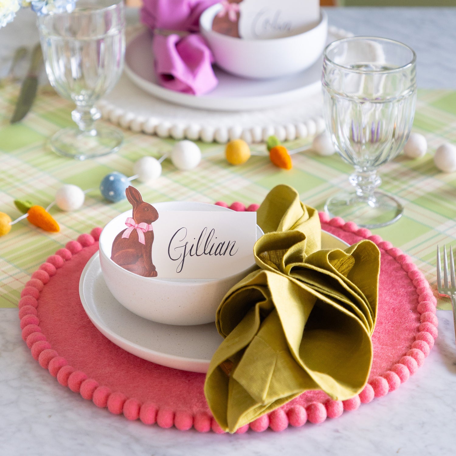 Easter table setting featuring the Pink Pom Felt Placemat, white dinnerware, Hershey&