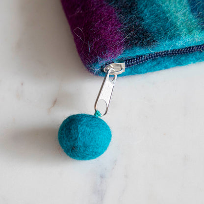 A close up of the Felt Rainbow Pouch with the felt pom at the end of the zipper pull.