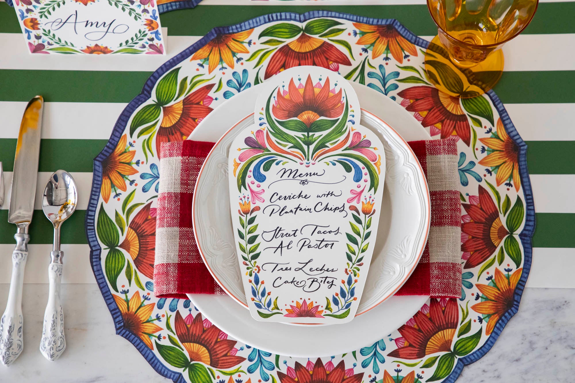 A table setting with colorful plates and napkins adorned with Hester &amp; Cook&