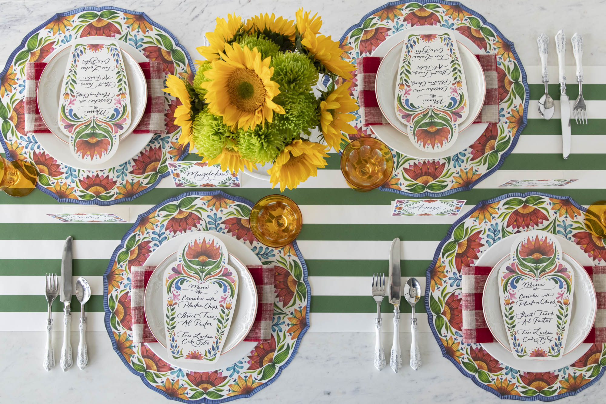 A colorful table setting with sunflowers, plates, and Die-cut Fiesta Floral Placemats from Hester &amp; Cook.