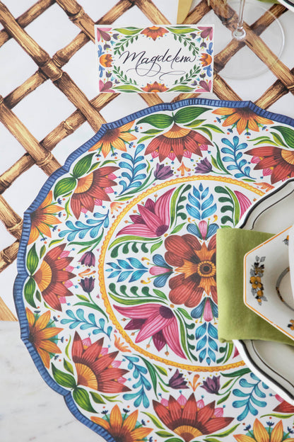 A table setting with a Die-cut Fiesta Floral Placemat by Hester &amp; Cook and a cup of coffee.