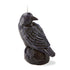 Black candle shaped like a crow on a white background