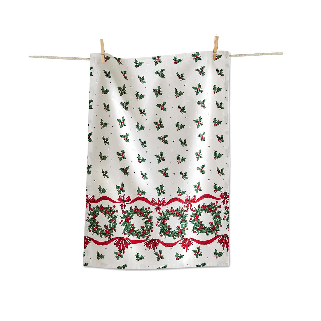 A tea towel with a white background and small holly and berries printed all over it with a line of holly wreaths on the bottom. 