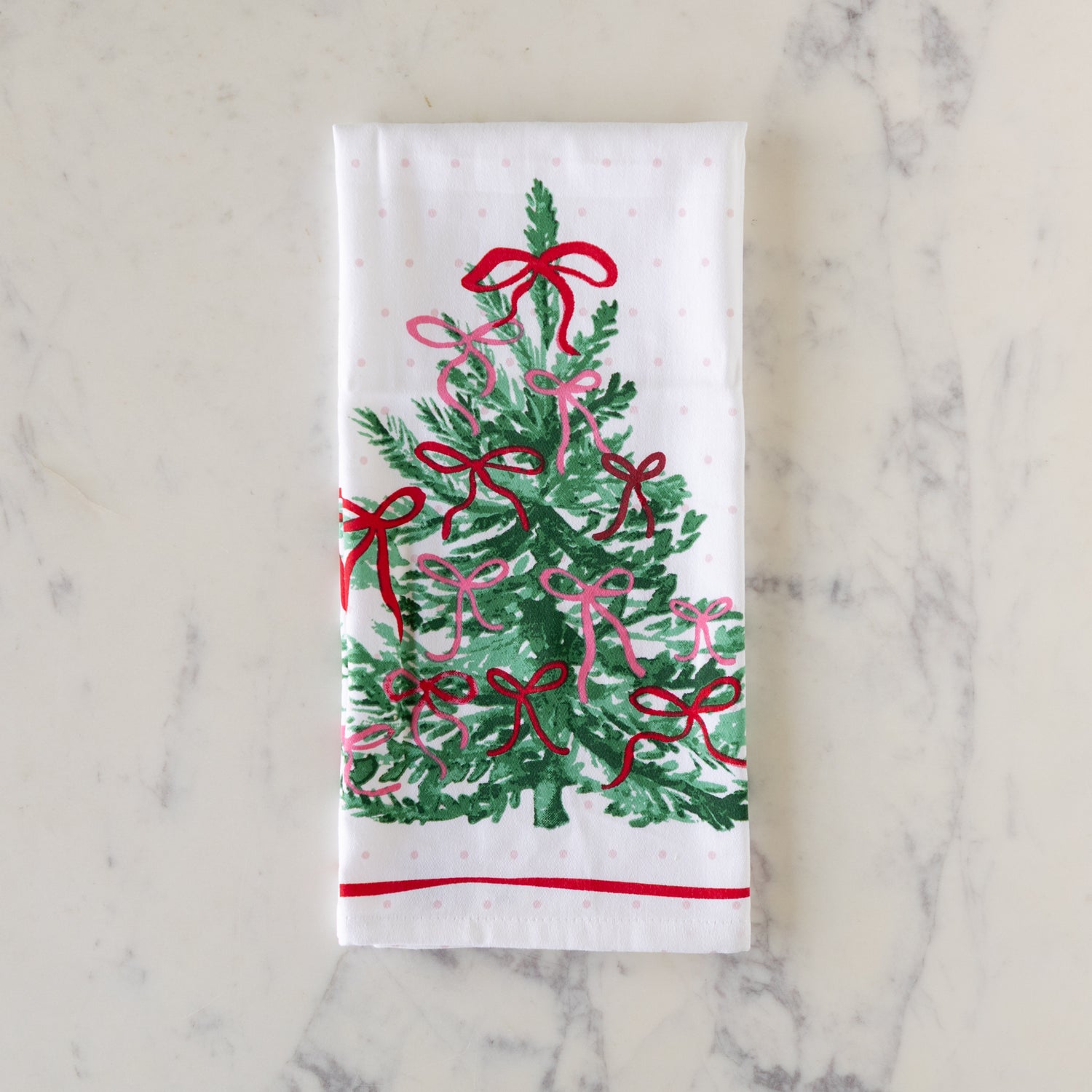Very Merry Dishtowel, folded, on a marble table.