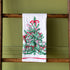 Very Merry Dishtowel hung on a wooden ladder.