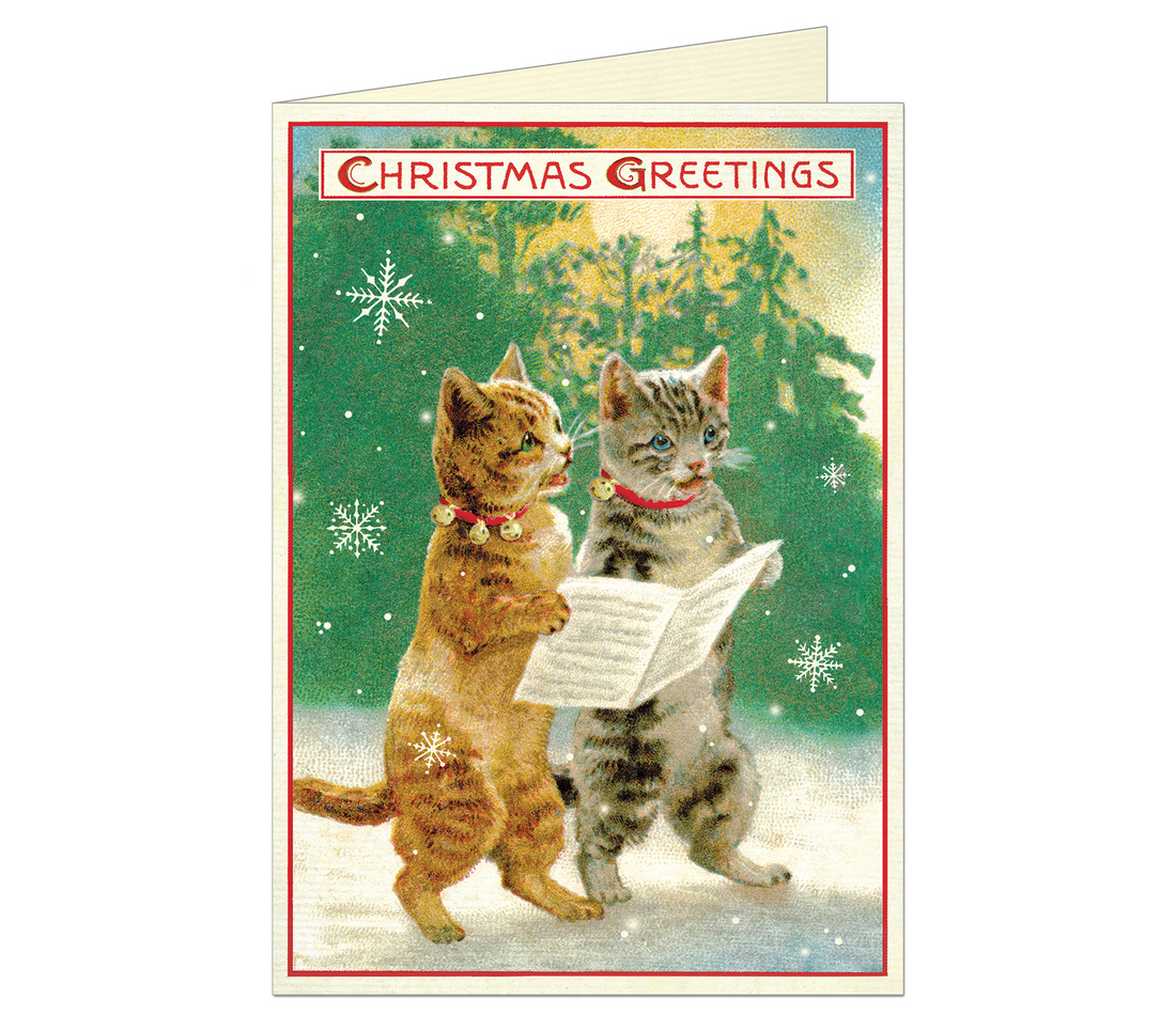 Christmas Cats Greeting Card showing two cats holding a paper in a snowy woods scene and  &quot;Christmas Greetings&quot; at the top of the card.