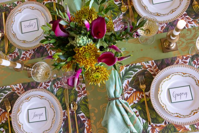 Decorative table setting with floral centerpiece, plates, and place cards.