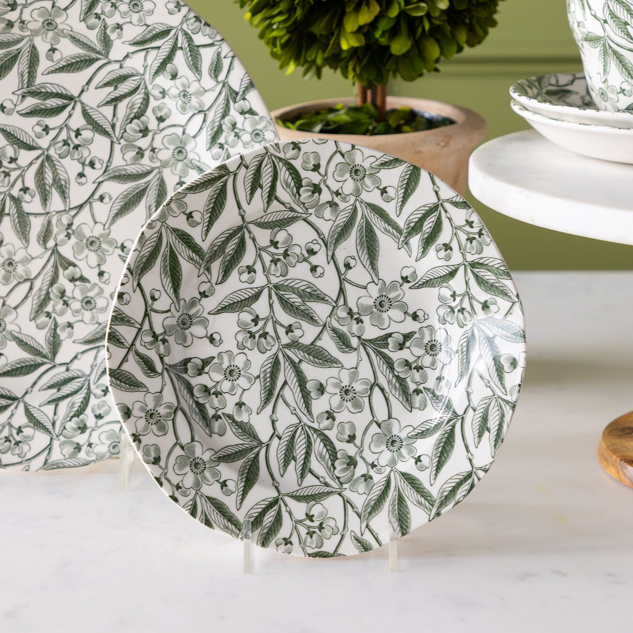 Burleigh Green Prunus Salad Plate propped on a clear stand.