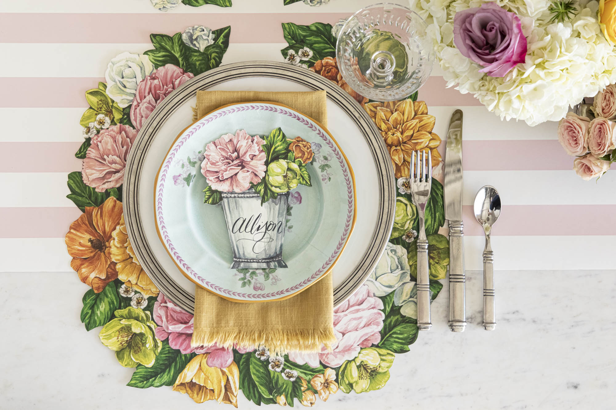 A race day table setting with plates, silverware, and flowers adorned with Hester &amp; Cook&