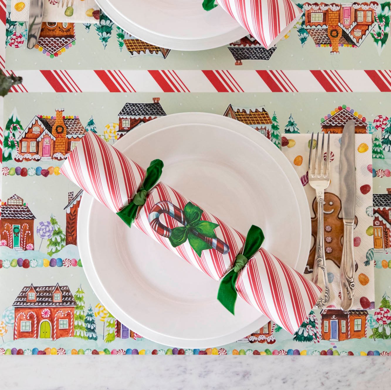 The Candy Cane Cracker resting on a plate on a Gingerbread themed table setting.