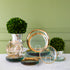 Annie Glass Roman Antique Dinnerware, Edgy Salad Plates, and Cheetah Print Plates all stacked up and displayed with Boxwood Topiary on a marble table.