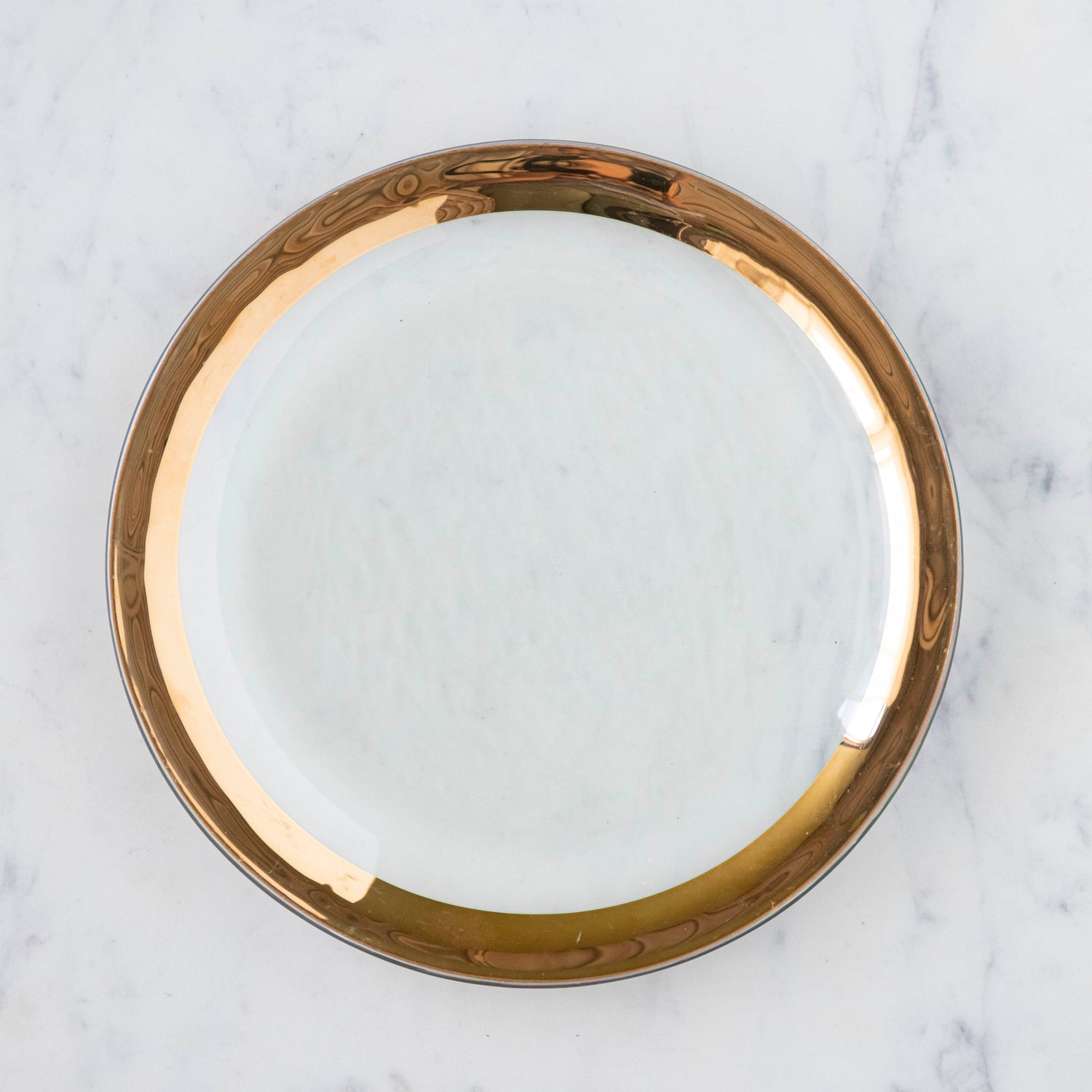 Annie Glass Roman Antique Buffet Plate, adorned with a 24-karat gold band, on a marble table.