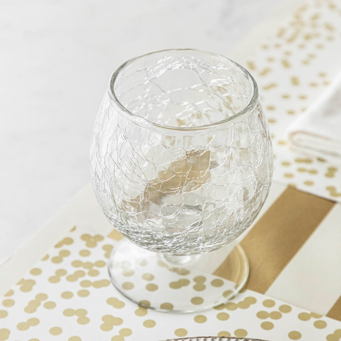 A glass of wine on a table next to Norwell Goblets by Design Ideas.