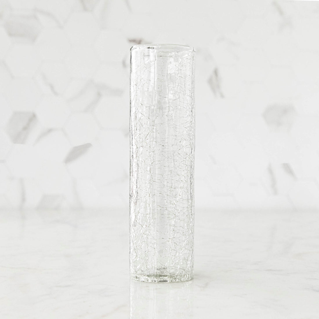 A tall Norwell Champagne Flute sitting on top of a marble counter.