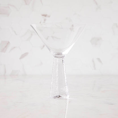 A clear Livogno Hammered Stem Glassware Champagne Flute on a white surface by Zodax.