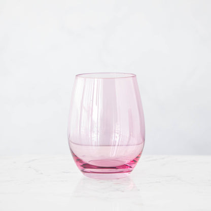 A pink crystal stemware wine glass on a marble table.