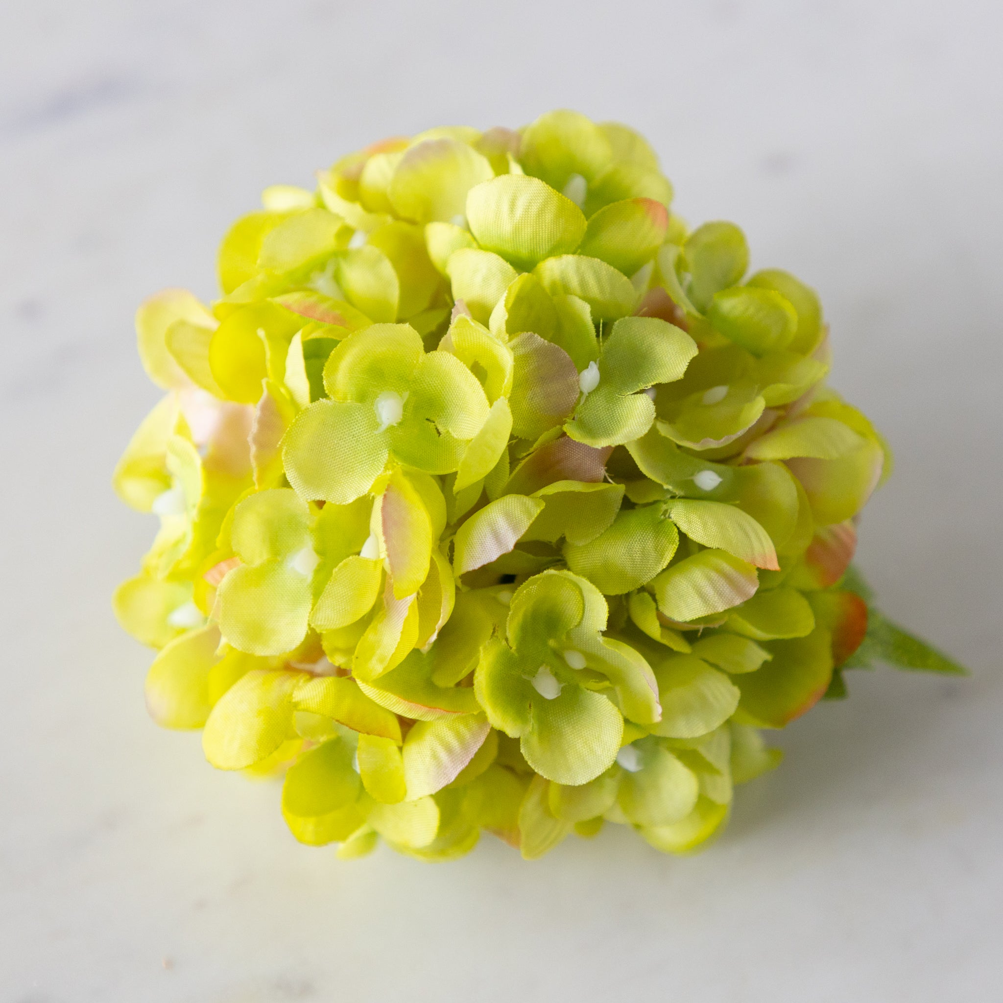 Green Hydrangea Napkin Ring on a marble surface.