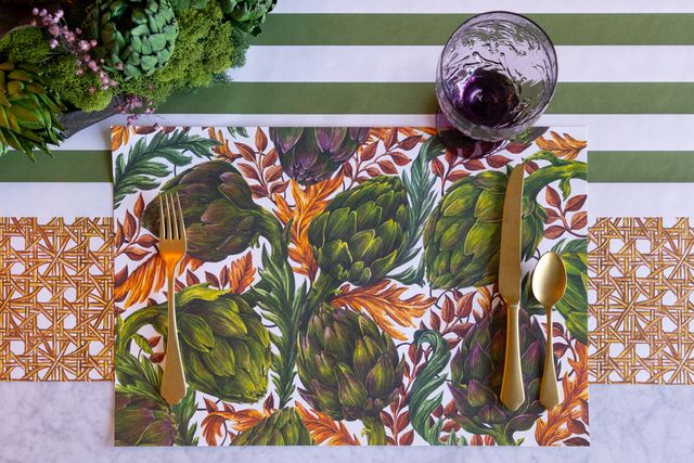 Placemat with leaf pattern on a table setting with cutlery and glass.