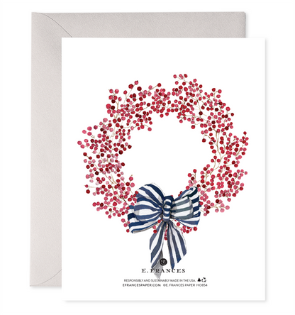 back of card with illustration of red berry wreath with blue &amp; white ribbon tied to the bottom. 