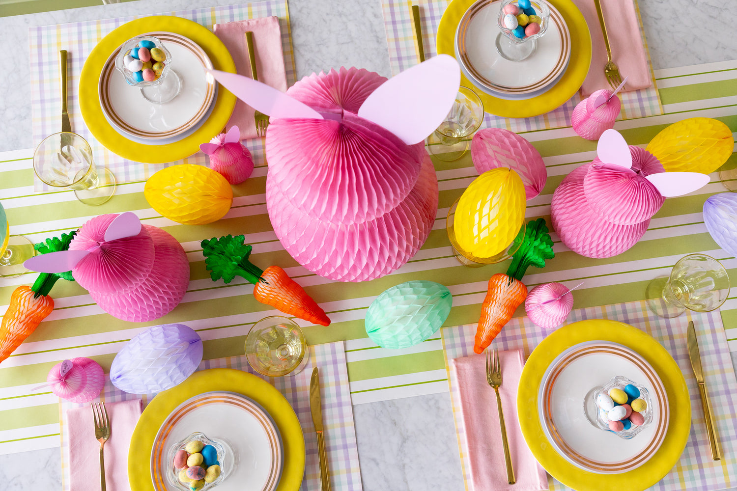 Colorful Easter table setting with Honeycomb Easter Eggs, bunnies and carrots.