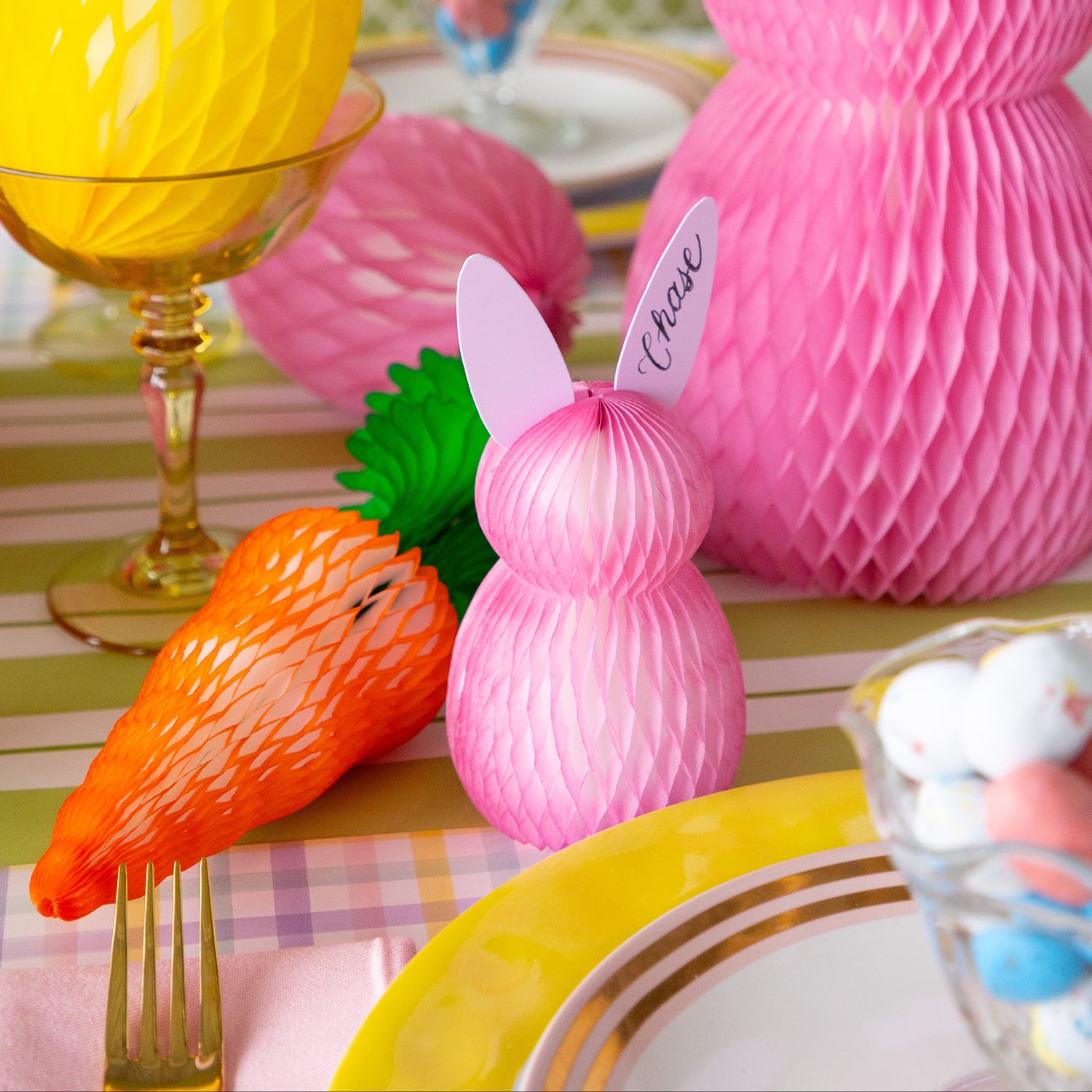 Decorative Easter table setting with colorful honeycomb bunnies, carrots and eggs.