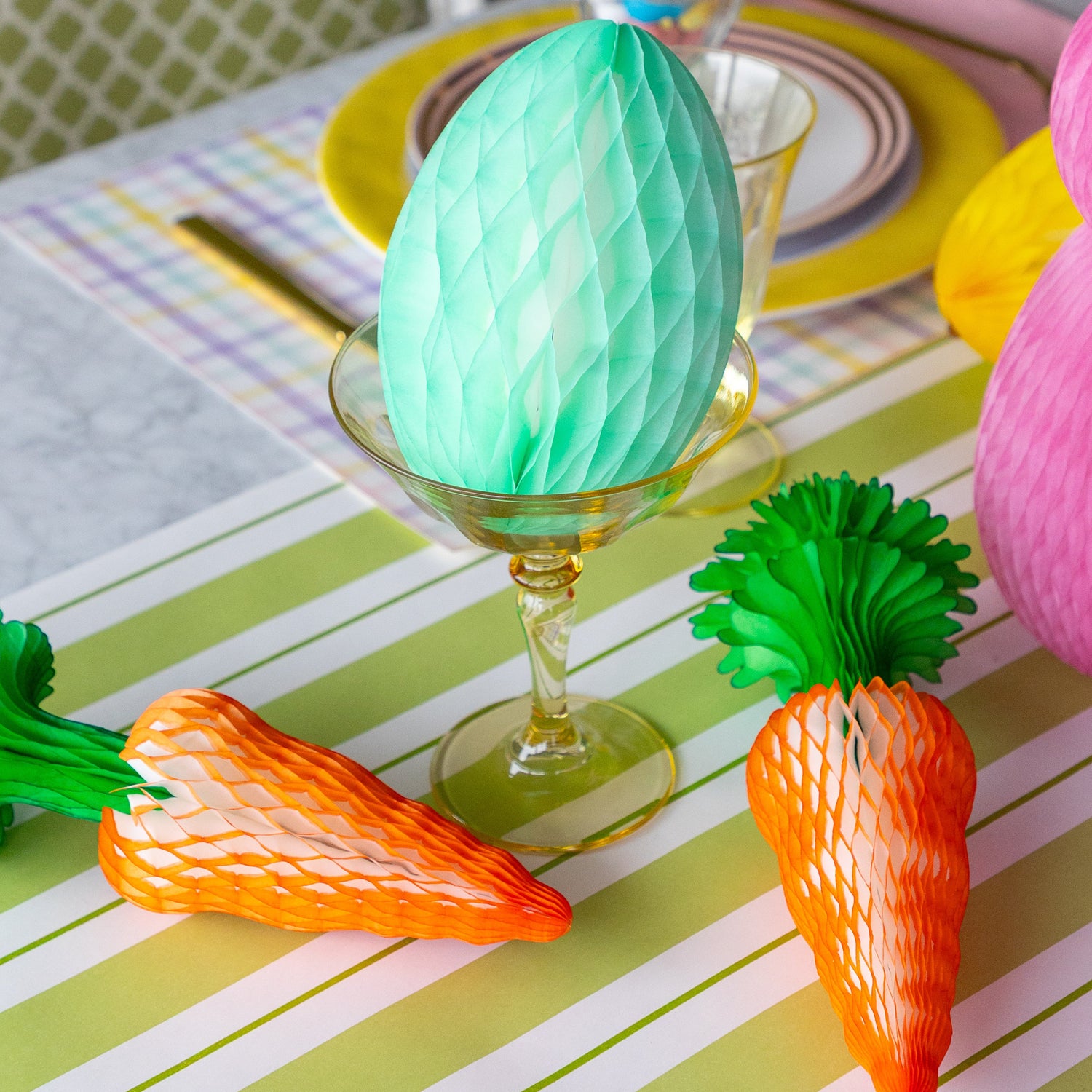 Colorful Easter table setting with Honeycomb Easter Eggs, bunnies and carrots.
