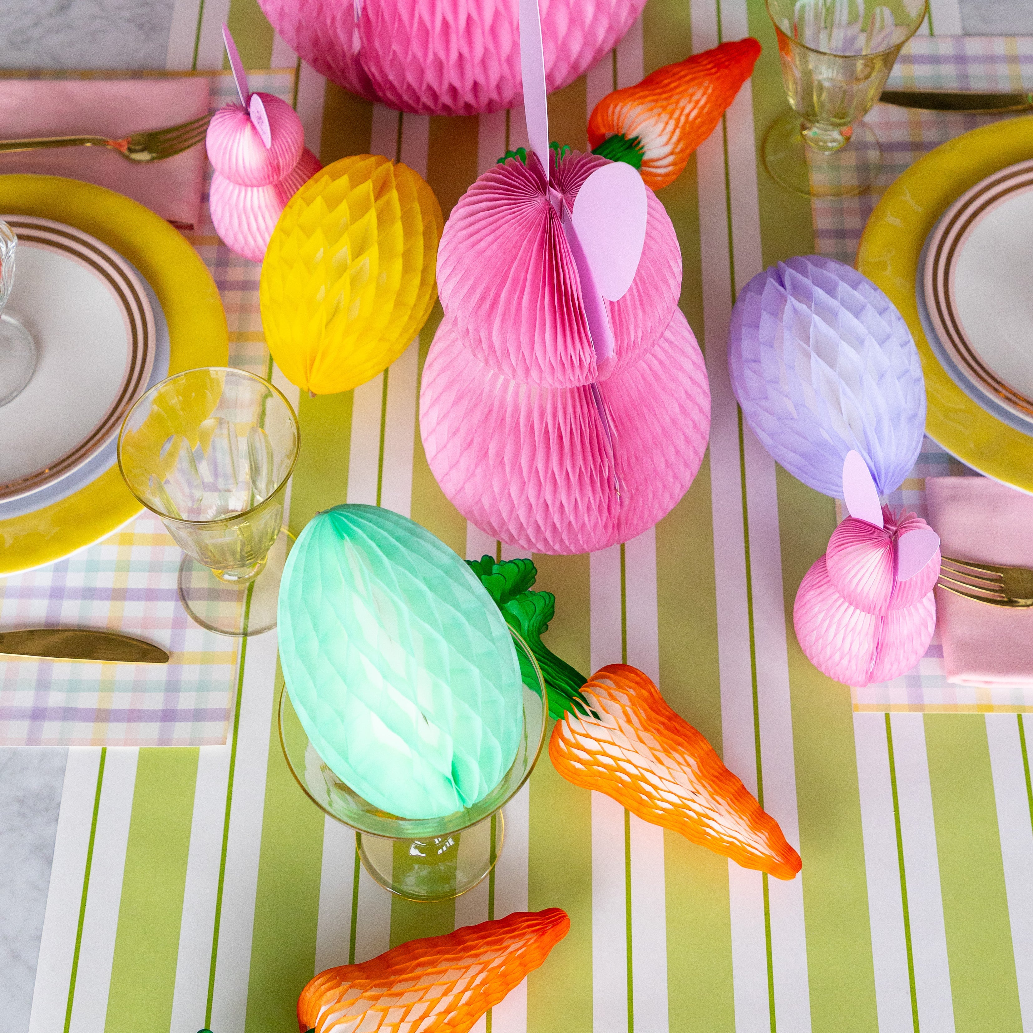 Colorful Easter table setting with Honeycomb Easter Eggs, bunnies and carrots.