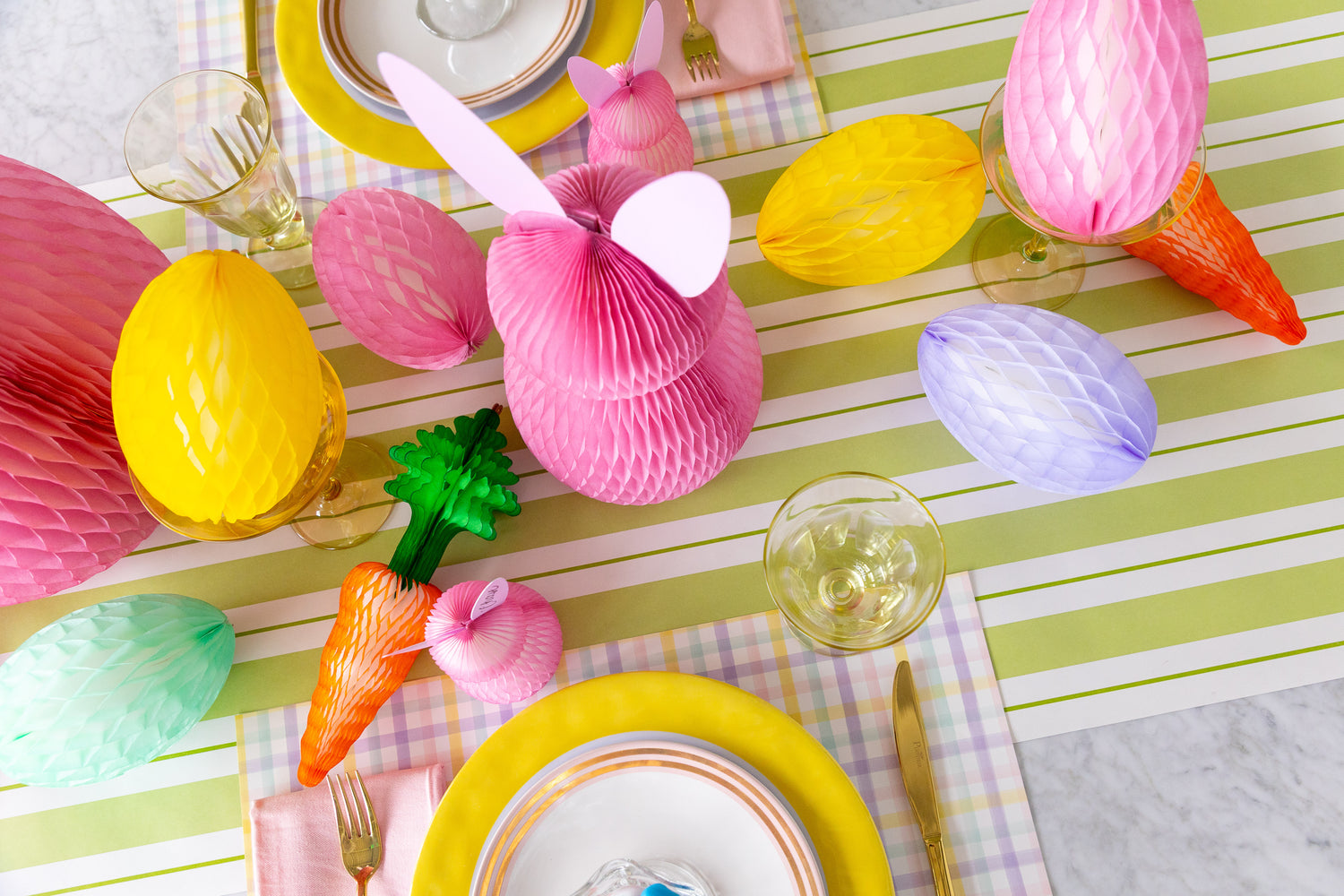 Colorful Easter table setting with Honeycomb Easter Eggs, bunnies and carrots.