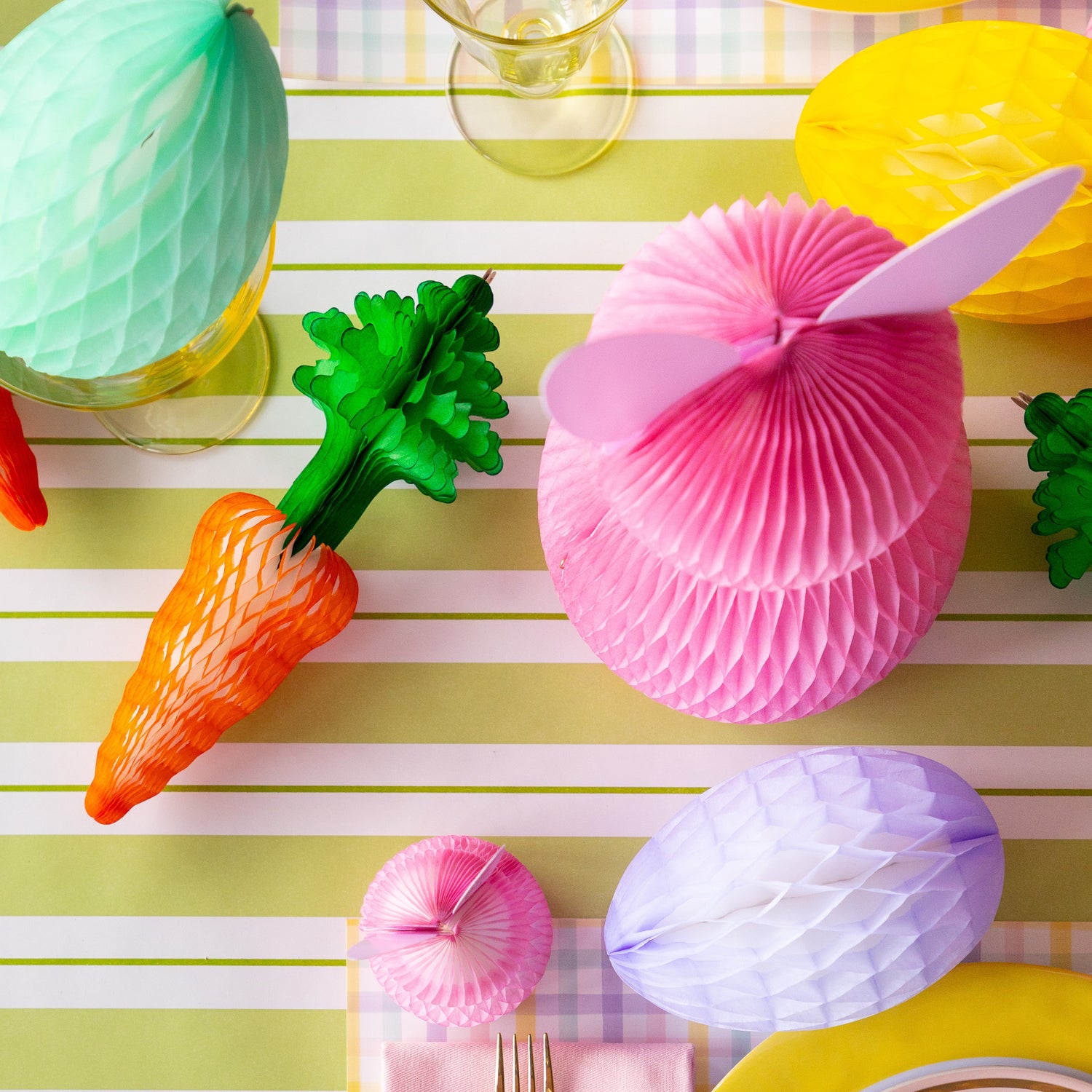 Colorful Easter table setting with Honeycomb Easter Eggs, bunnies and carrots.