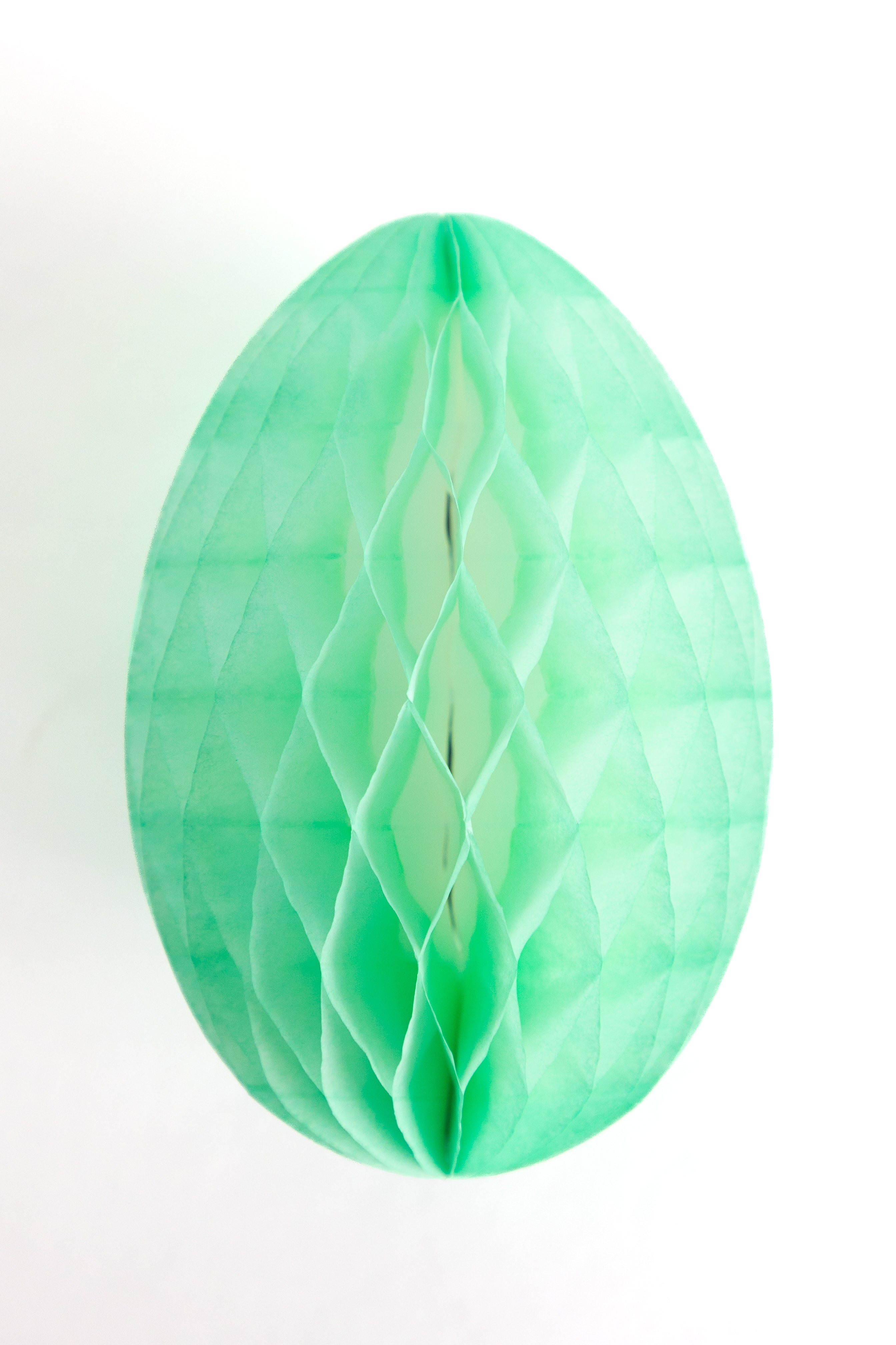 Green honeycomb Easter egg on a white background.
