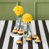 Candy corn themed tea light candles with flowers on a black stripe runner.