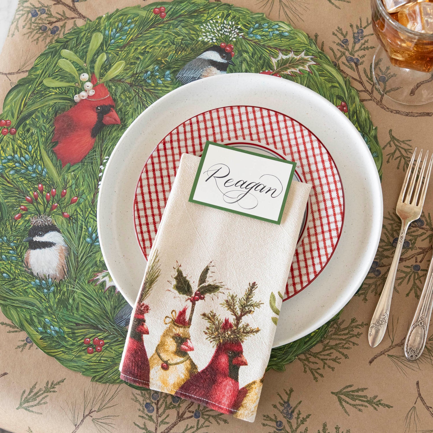 A nature themed table setting featuring the Holiday Party Cardinal Napkin resting on dinner plates.