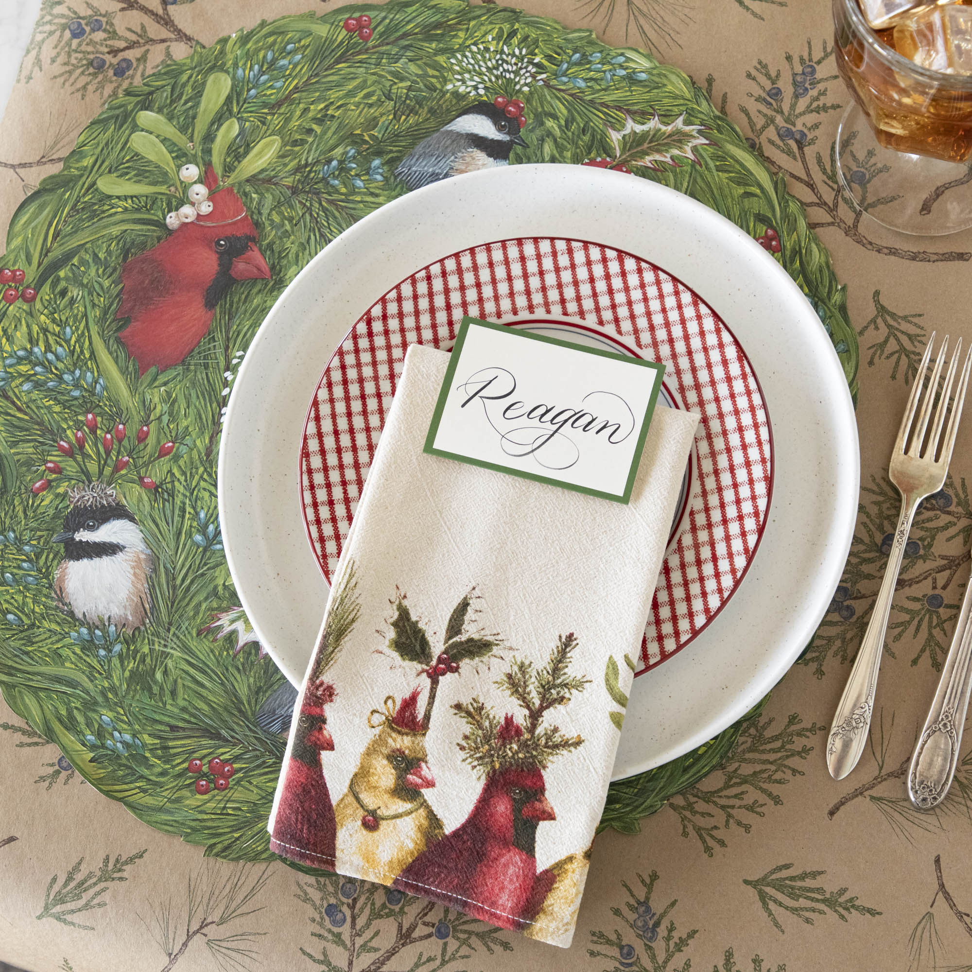 A nature themed table setting featuring the Holiday Party Cardinal Napkin resting on dinner plates.